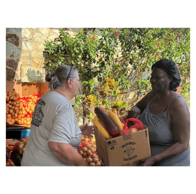 Debara Milton receives a box of produce at an Immokalee food distribution