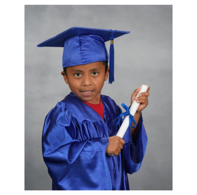 Santiago in a cap and gown holding his Pathways graduation diploma