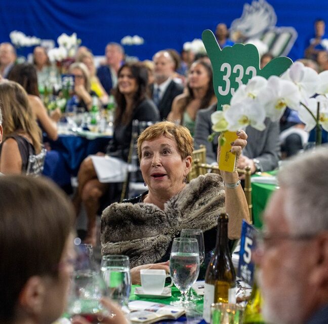 Guest raises a bid paddle during the auction at FGCU's Night at the Nest gala
