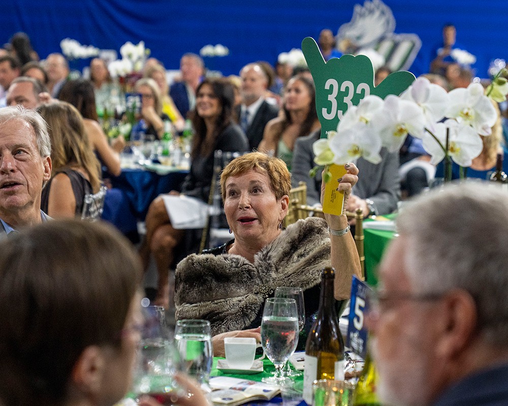 Guest raises a bid paddle during the auction at FGCU's Night at the Nest gala