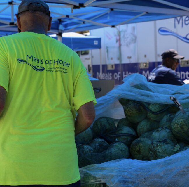 Meals of Hope volunteer carrying watermelons at a Collier County food distribution
