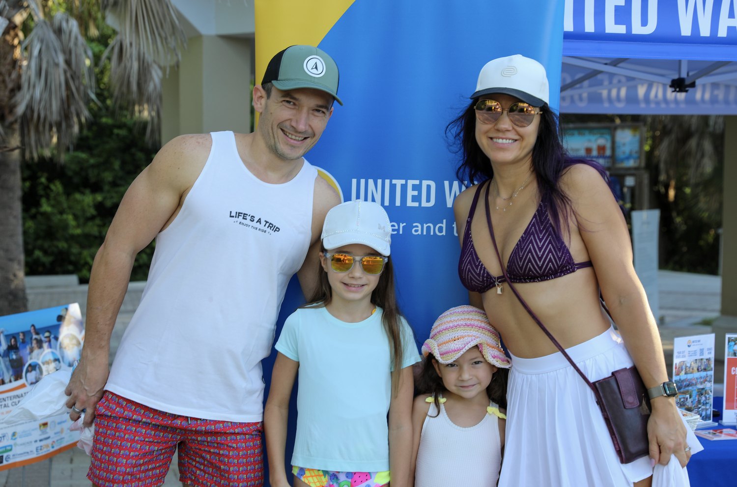 Family of four at the United Way banner during the coastal cleanup