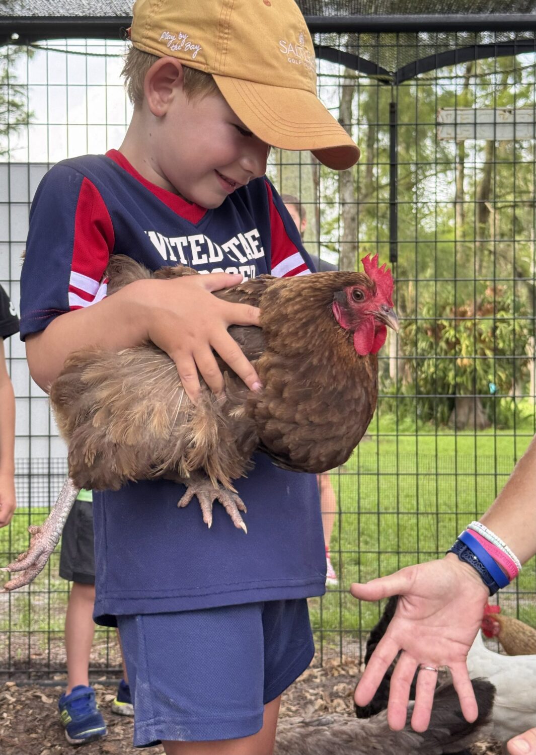Summer camper holding Laverne the hen at Empowerment Farm