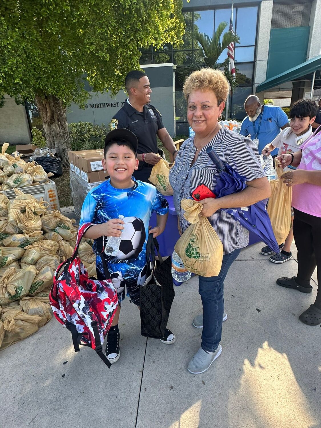 Grandmother and boy carrying groceries and a backpack from a Farm Share event