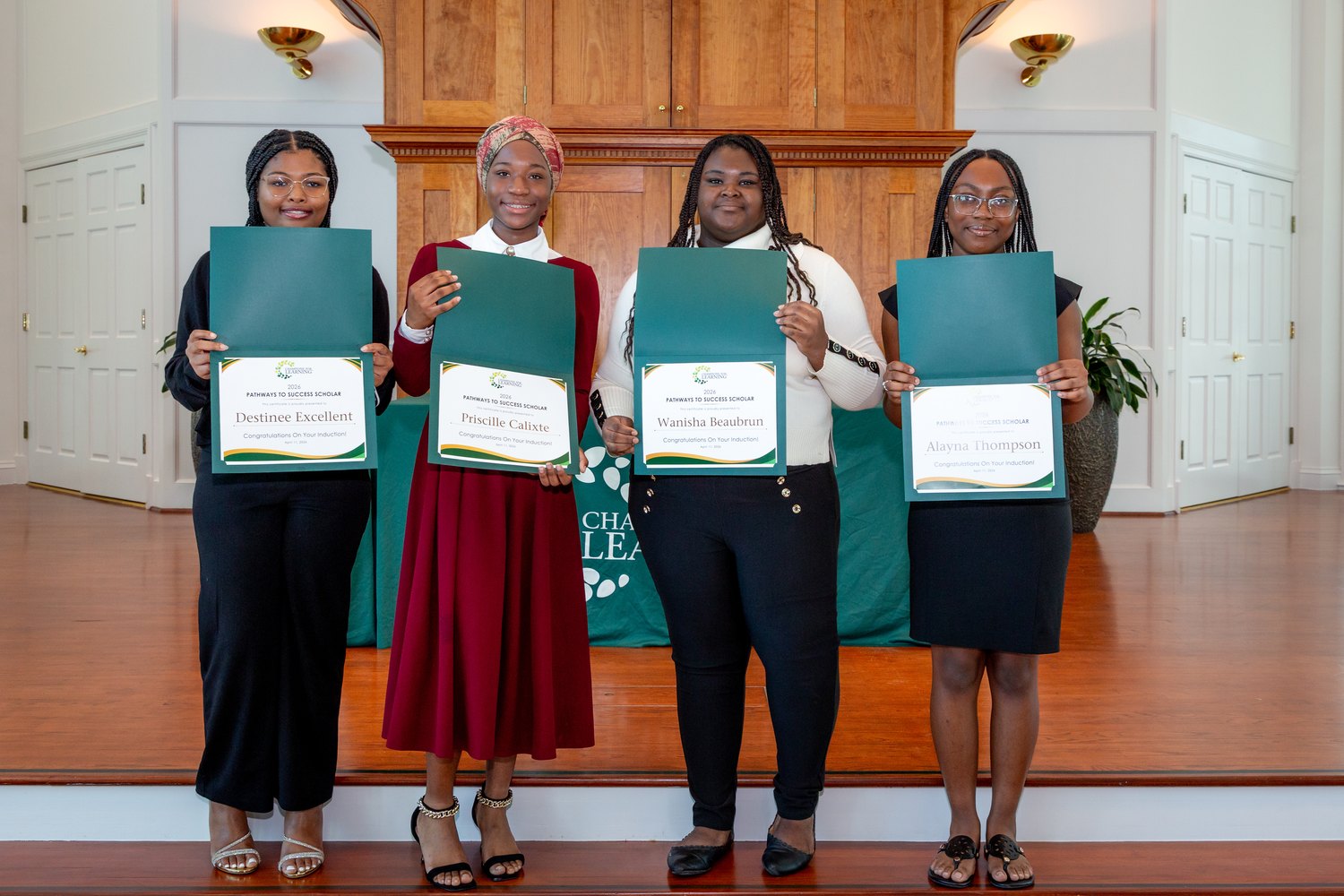 Four students holding certificates at the Champions For Learning induction ceremony