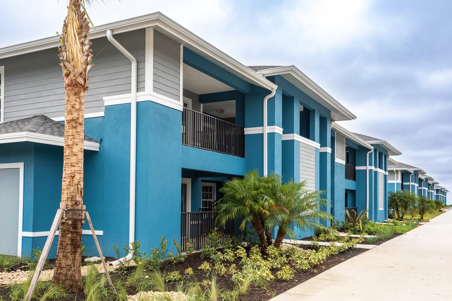 Row of completed blue and white townhomes at Las Palmas