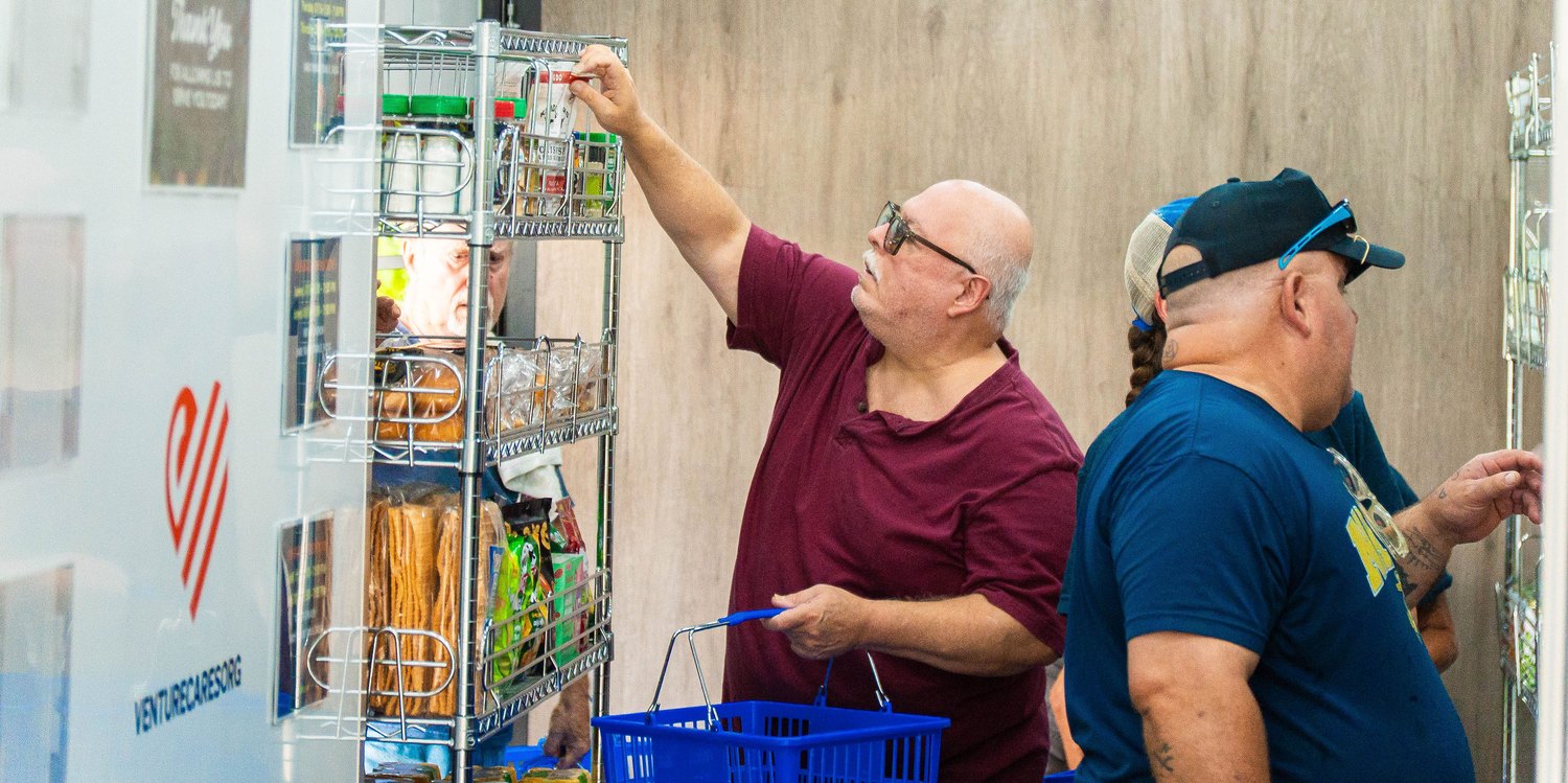 Volunteer stocking shelves at the Venture Cares mobile market