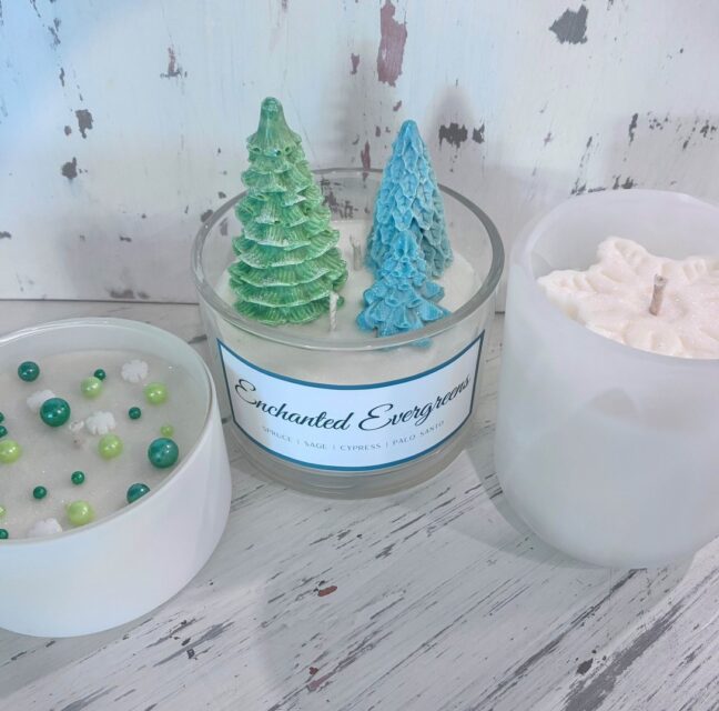 Holiday candles including an Enchanted Evergreen candle and decorative trees