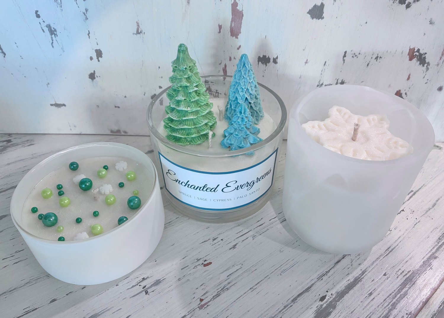 Holiday candles including an Enchanted Evergreen candle and decorative trees