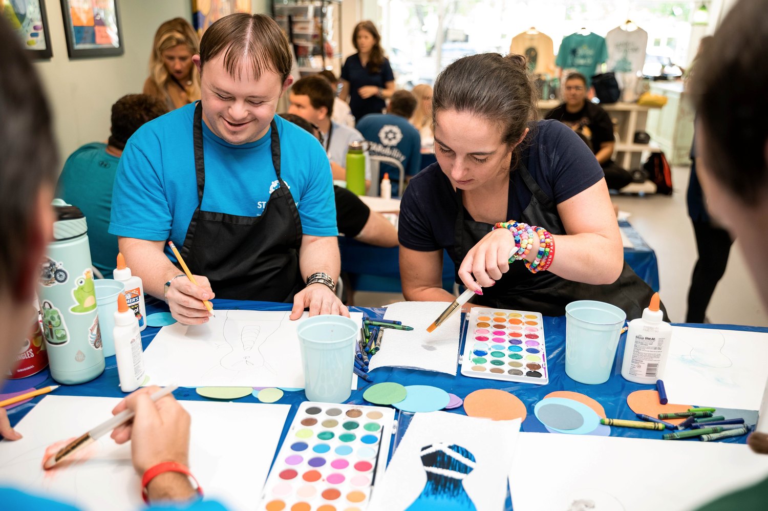 STAR Studio participants painting artwork together at a worktable